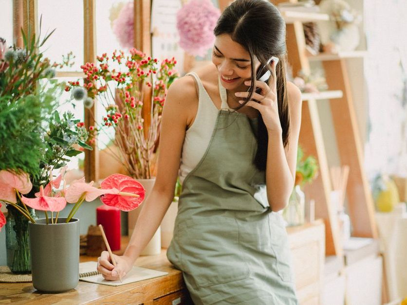A small-business owner taking a booking on her phone.